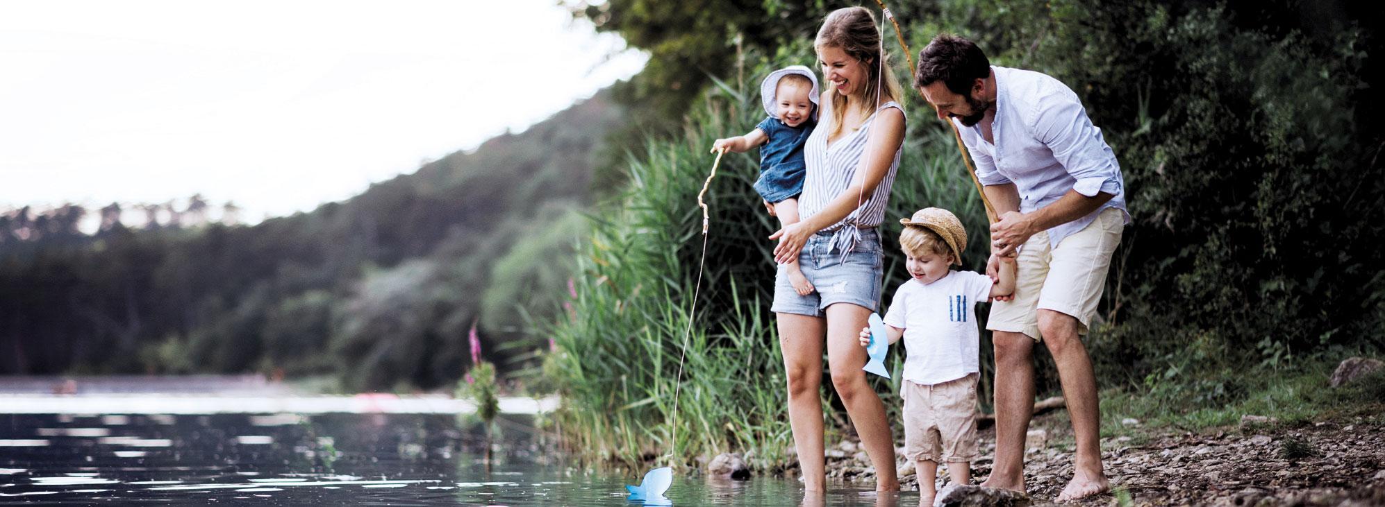 Junge Familie, Mutter, Vater und zwei Kinder, verbringt gemeinsam Zeit in der Natur.